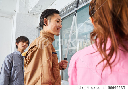 Young man wearing workwear painting paint on the wall Young man wearing workwear painting paint on the wall 66666385
