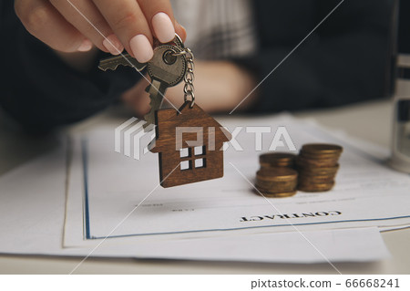 Close up wooden toy house with Woman signs a purchase contract or mortgage for a home, Real estate concept. 66668241