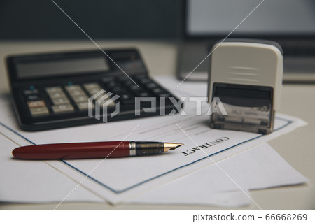 Close up woman hand using calculator and writing make note with calculate about cost at home office Close up woman hand using calculator and writing make note with calculate about cost at home office 66668269