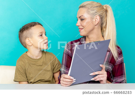 Young little schoolboy doing homework with mother, cooperation in family, parenthood Young little schoolboy doing homework with mother, cooperation in family, parenthood 66668283