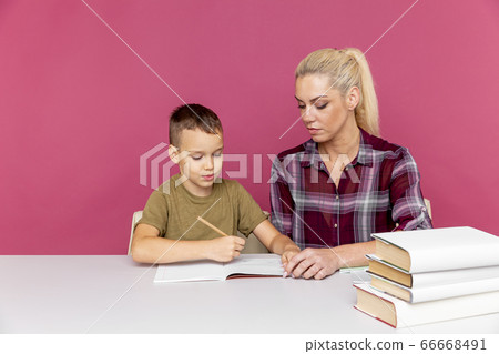 Mother with son at home doing homework together in quarantine time. Mother with son at home doing homework together in quarantine time. 66668491