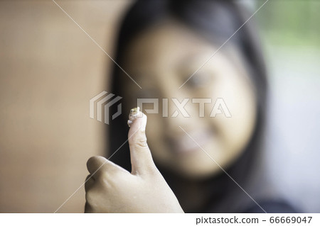 One small frog perched on the girl's finger. 66669047