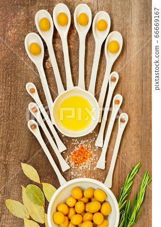 Pattern of ceramic spoons with olives and spices. Pattern of ceramic spoons with olives and spices. 66669167