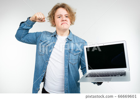 contented cool blond man holding a laptop with a layout for inserting a page on a white background contented cool blond man holding a laptop with a layout for inserting a page on a white background 66669601