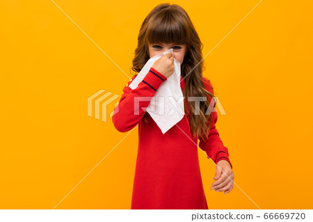 Beautiful little girl in dress plays with glasses isolated on yellow and orange background Beautiful little girl in dress plays with glasses isolated on yellow and orange background 66669720