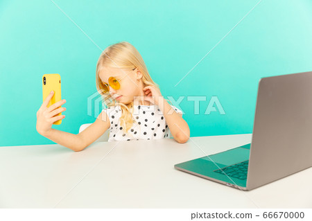 Happy girl at home speaking in front of camera for vlog. kid making self photo and video working as blogger, recording video tutorial for Internet. 66670000