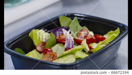 Chef preparing fresh salad for takeaway delivery order Chef preparing fresh salad for takeaway delivery order 66672394