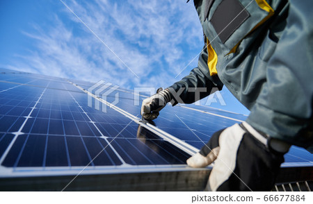 Male worker repairing photovoltaic solar panel. 66677884