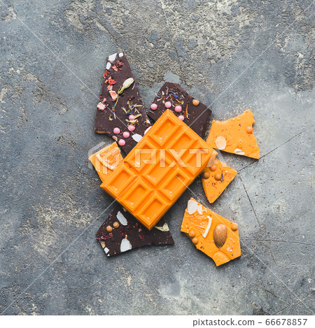 Chocolate bright orange fruit whole tile decorated with slices fruit nuts and slices on a gray background. Minimization Chocolate bright orange fruit whole tile decorated with slices fruit nuts and slices on a gray background. Minimization 66678857