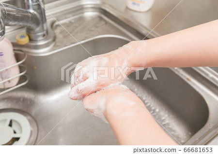 Women washing their hands in the kitchen Women washing their hands in the kitchen 66681653