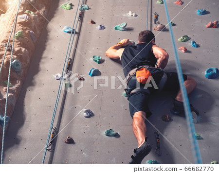 A man climbing in boulder gym in the wall. 66682770