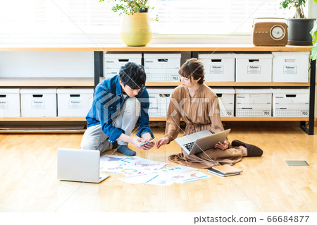 Man and woman sitting on the office floor Man and woman sitting on the office floor 66684877
