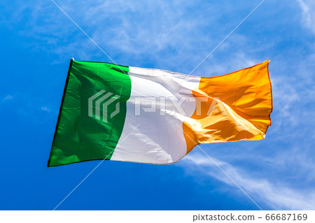 Irish flag fluttering in a brisk breeze against a 66687169
