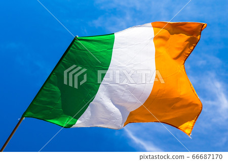 Irish flag fluttering in a brisk breeze against a 66687170