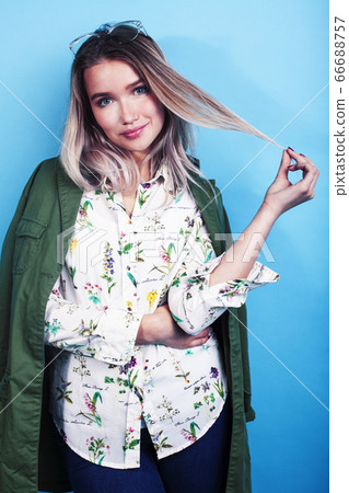 young pretty girl posing happy smiling on blue background, lifestyle people on summer vacation concept young pretty girl posing happy smiling on blue background, lifestyle people on summer vacation concept 66688757