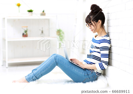 女人在家接觸一台筆記本電腦 66689911