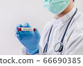 The doctor holds a test tube containing a blood sample 66690385