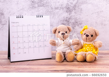couple teddy bear with calendar on table wooden. couple teddy bear with calendar on table wooden. 66692650