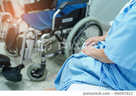 Asian senior or elderly old lady woman patient sitting on bed with electric wheelchair 66693922