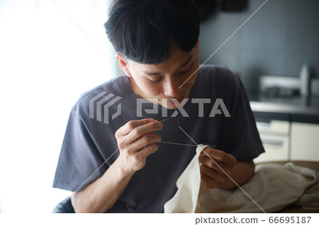 Men putting buttons on clothes Men putting buttons on clothes 66695187