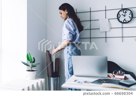 Young female designer taking roll of paper 66698304