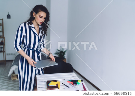 Independent swell woman in trendy dress beginning work at home 66698515