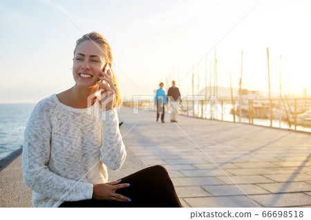 Smiling female lawyer is talking on mobile phone about her winning trial 66698518