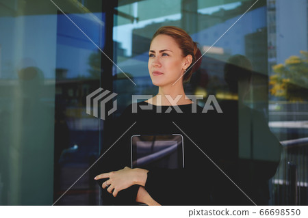 Portrait of beautiful young female holding mobile phone in hands  66698550