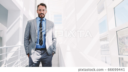 Handsome happy intelligent man in luxury suit relaxing after work day 66699441