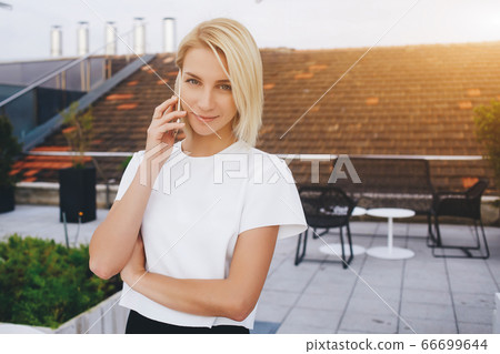 Smiling female lawyer is talking on mobile phone about her winning trial 66699644