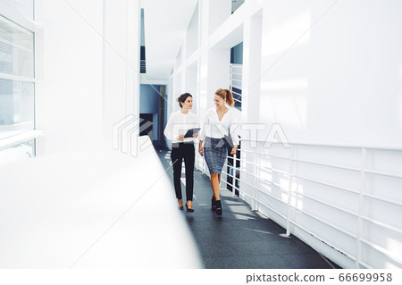 , confident women entrepreneurs working on touch pad while going to the conference room 66699958