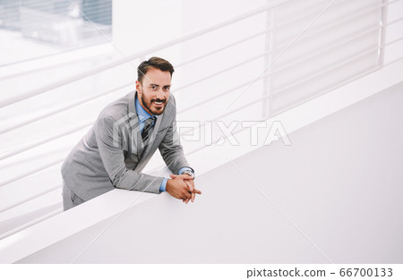 Male intelligent CEO is waiting business partners in hallway his company Male intelligent CEO is waiting business partners in hallway his company 66700133