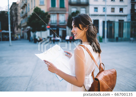 Cheerful tourist with map looking away,and square of tourist city 66700135