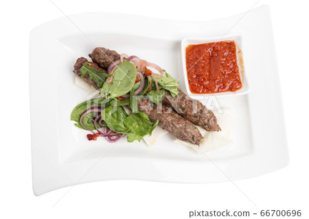 Beef kebab with spicy tomato sauce on skewers. 66700696