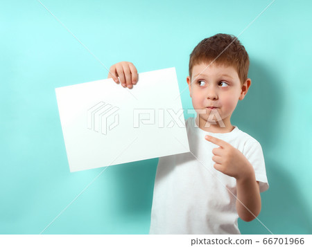 Little boy holds blank paper sheet, blue background 66701966