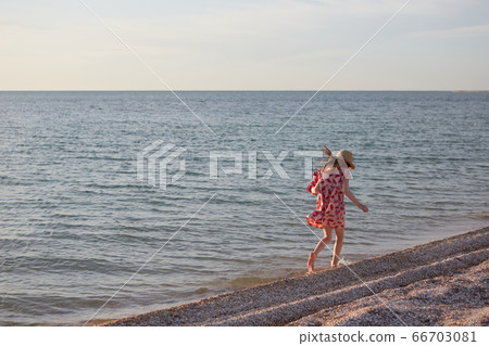 Little girl running beach shore splashing water in blue sea 66703081