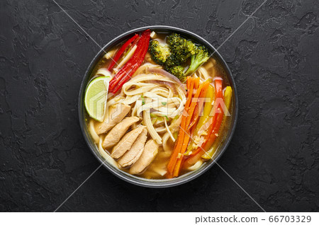 Chicken Thukpa in black bowl at dark slate background. Chicken Thukpa is Tibetan cuisine noodle soup Chicken Thukpa in black bowl at dark slate background. Chicken Thukpa is Tibetan cuisine noodle soup 66703329