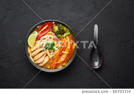 Chicken Thukpa in black bowl at dark slate background. Chicken Thukpa is Tibetan cuisine noodle soup Chicken Thukpa in black bowl at dark slate background. Chicken Thukpa is Tibetan cuisine noodle soup 66703334