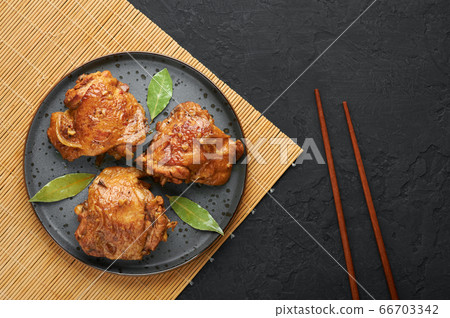 Filipino Chicken Adobo on dark gray plate on black slate. Filipino food. Braised chicken thighs Filipino Chicken Adobo on dark gray plate on black slate. Filipino food. Braised chicken thighs 66703342