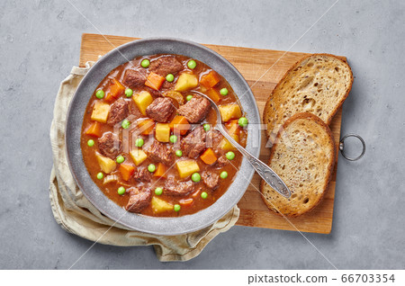 Irish Beef Stew in matt gray bowl on concrete table top. Stew with beef or lamb meat  66703354