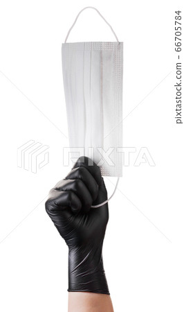 Hand in black gloves holding disposable face mask 66705784