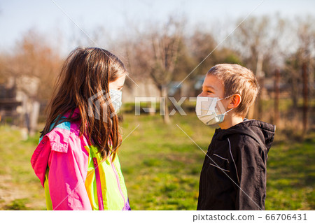 Brother and sister in protective masks outdoors 66706431