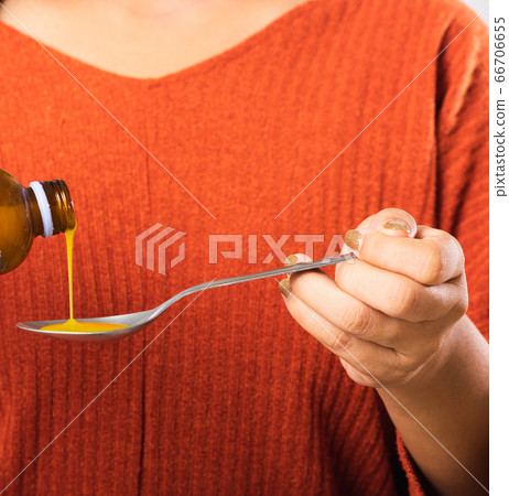 mother woman pouring liquid medication or mother woman pouring liquid medication or 66706655