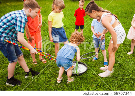 Group of little kids learning to make big soap bubbles Group of little kids learning to make big soap bubbles 66707344