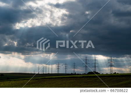 Pylons With High Voltage Energy Wires In Farmland At Stormy Weather  66708622