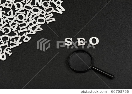 SEO word written from wood letters and magnifying 66708766