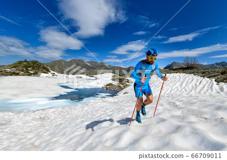 Skyrunner man uphill in a snowy stretch Skyrunner man uphill in a snowy stretch 66709011