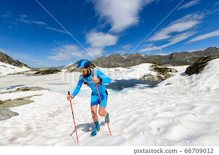 Skyrunner man in action going uphill on snow Skyrunner man in action going uphill on snow 66709012