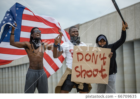 Black lives matter protests go global. three afroamerican people with posters in the street Black lives matter protests go global. three afroamerican people with posters in the street 66709635