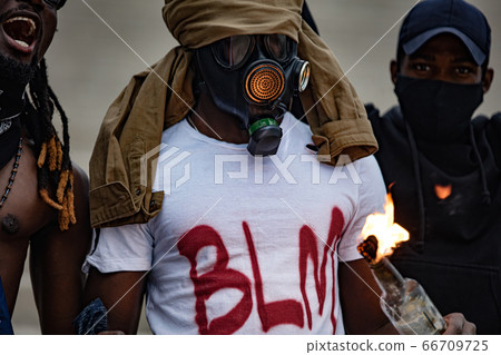 afroamerican men hold burning glass bottle in hands 66709725